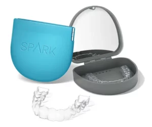 Spark clear aligner tray balanced on a fingertip